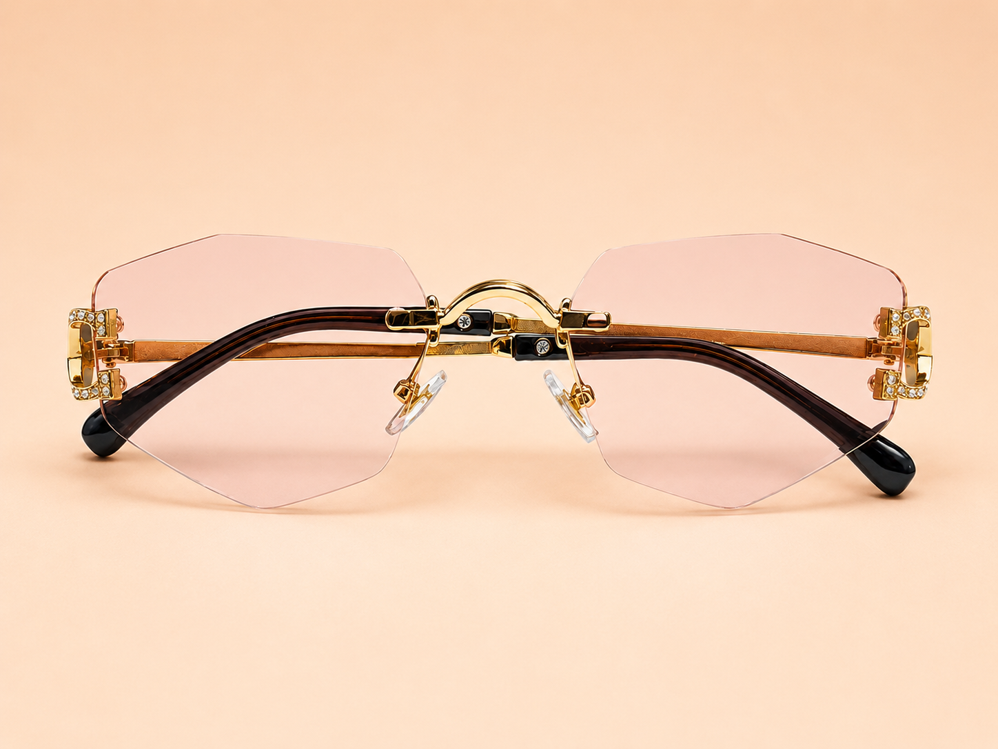 Rimless geometric sunglasses from NeXova UK with blush pink lenses and gold-tone frame details