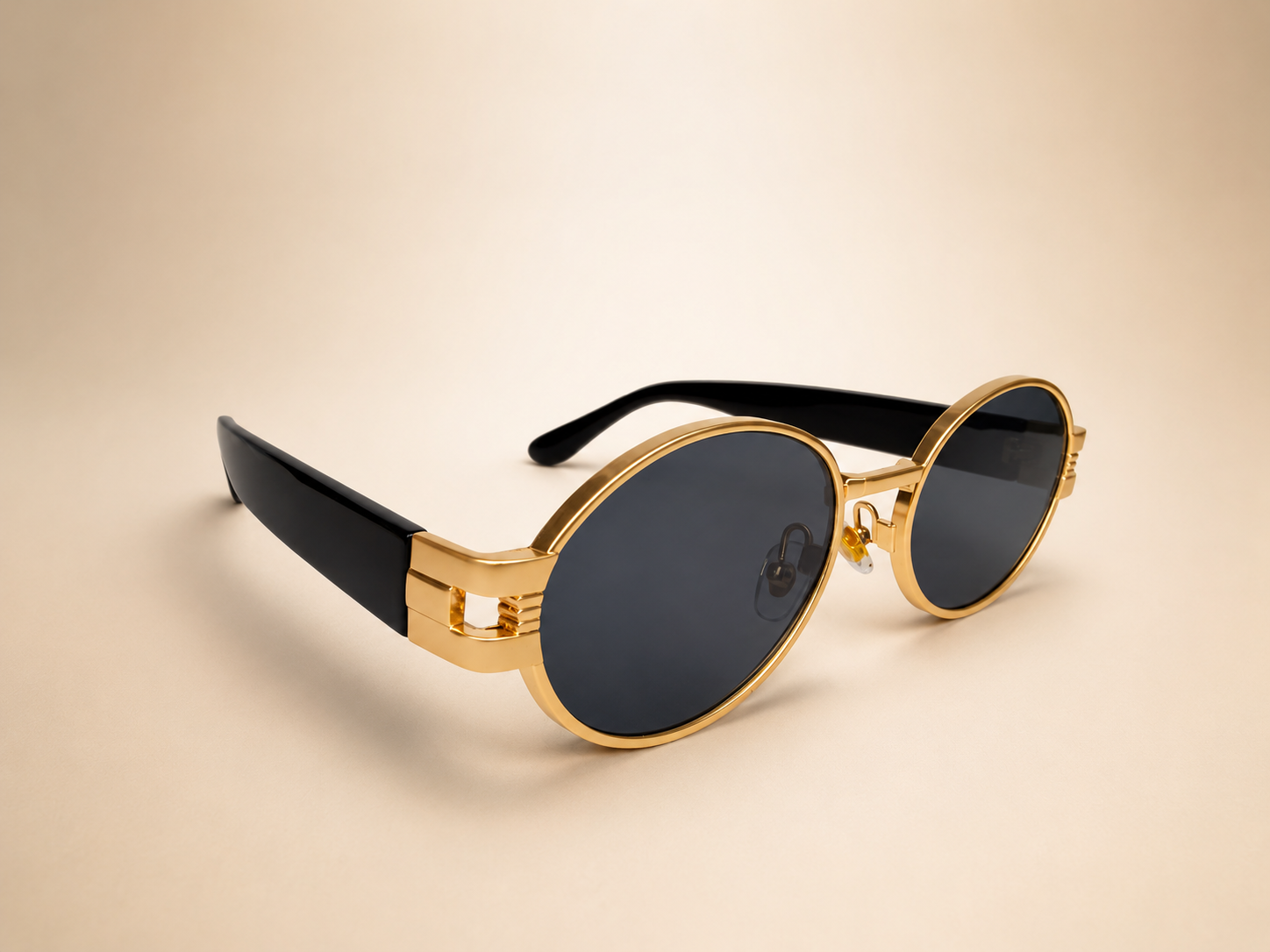Front view of gold oval sunglasses with smoke black lenses and black side arms