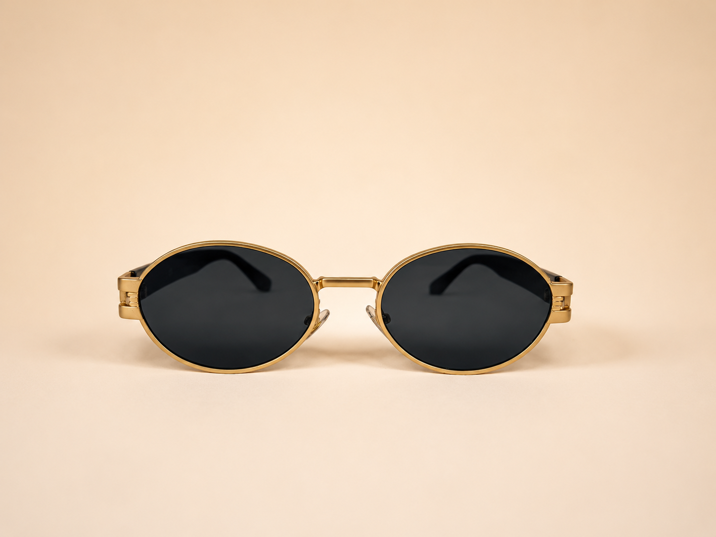 Front view of gold oval sunglasses with smoke black lenses and black side arms