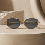 Rimless oval unisex sunglasses from NeXova UK with smoke grey lenses, gold-tone bridge and cream temples