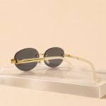 Rimless oval unisex sunglasses from NeXova UK with smoke grey lenses, gold-tone bridge and cream temples