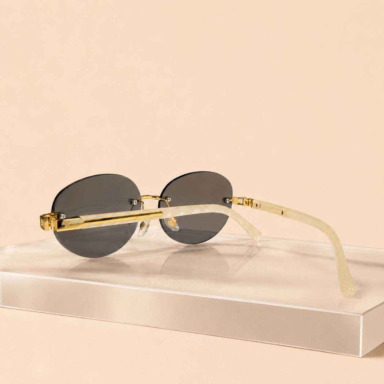 Rimless oval unisex sunglasses from NeXova UK with smoke grey lenses, gold-tone bridge and cream temples