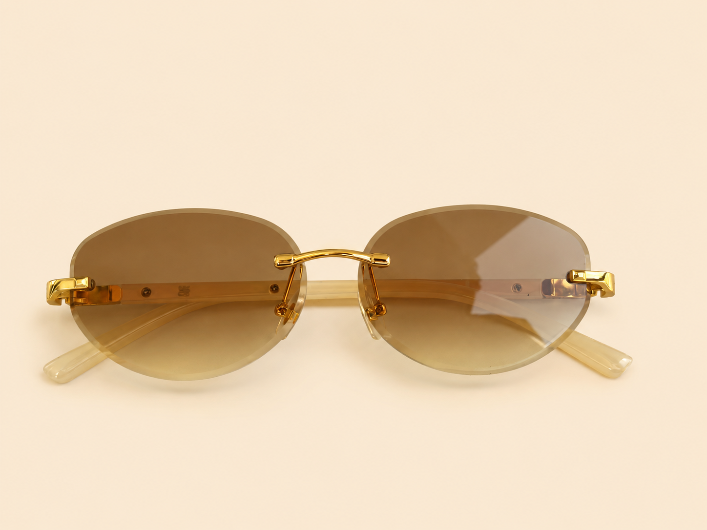 Rimless oval unisex sunglasses from NeXova UK with warm brown lenses, gold-tone bridge and cream temples