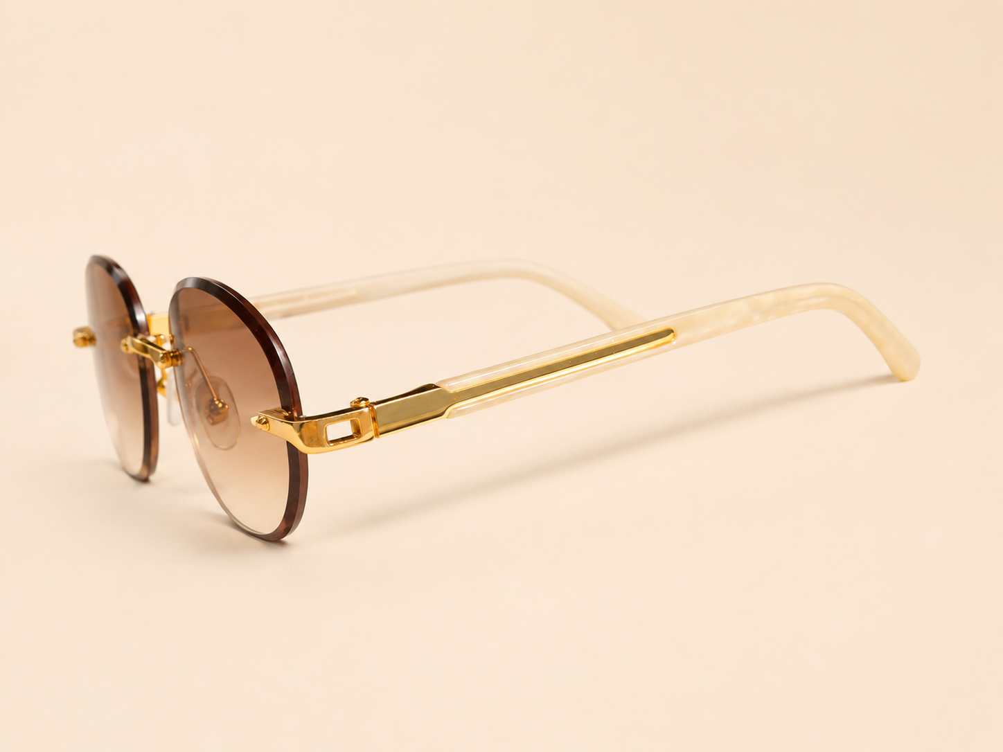 Rimless oval unisex sunglasses from NeXova UK with warm brown lenses, gold-tone bridge and cream temples