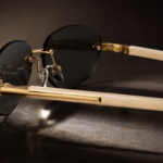 Rimless oval unisex sunglasses from NeXova UK with blacklenses, gold-tone bridge and cream temples