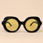 Black round unisex sunglasses from NeXova UK with glossy black frame and yellow tinted lenses