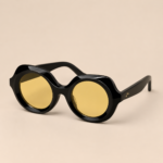 Black round unisex sunglasses with glossy black frame and yellow tinted lenses